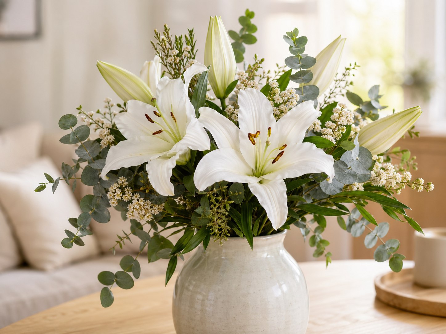 White sympathy bouquet resting on a wooden table in soft daylight